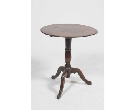 A Georgian oak tripod tableThe circular top supported on a ring turned shaft with three down swept supports, 58cm diameter.