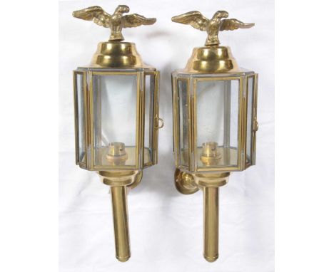 A pair of vintage brass trap lamps, early 20th CenturyEach applied with an eagle finial above the four panel glass lamps, lat