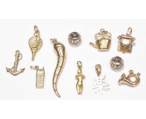 A selection of yellow metal and 9ct gold charms.To include a 9ct gold teapot charm, a 9ct gold telephone charm and several ot