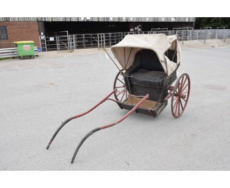 A rare single axle pony carriage, c.1900The wicker carriage body beneath a folding canvas canopy mounted on a single axle wit