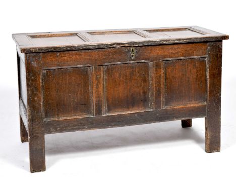 A 17th Century oak cofferHaving an inverted moulded three panel top above three conforming front panels, raised upon stile fe