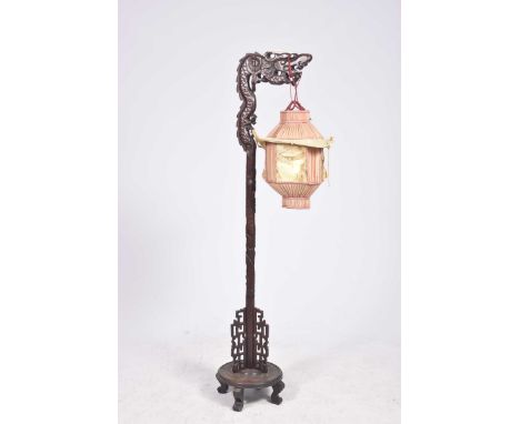 A Chinese carved hard wood standard lamp, circa 1930 The hard wood frame extending to a dragon formed terminal, and rising fr