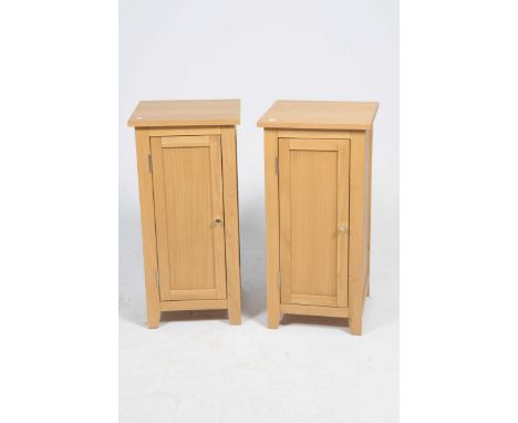 A pair of contemporary light oak bedside cabinetsEach with a square top above a panelled door enclosing a single shelf, 40x82