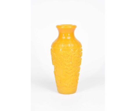 A Chinese yellow Peking glass vaseOf slender ovoid form, with folded swept upper rim, the body carved in relief with two drag