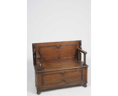 An early 20th Century oak Monks benchThe sliding rectangular top with geometric moulding above a hinged boxed section and two
