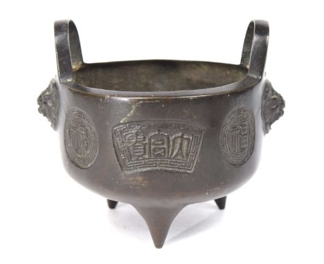 A Chinese cast metal censer, late Qing (1644-1912)Of circular form raised on three tapered feet cast to either side with Shis