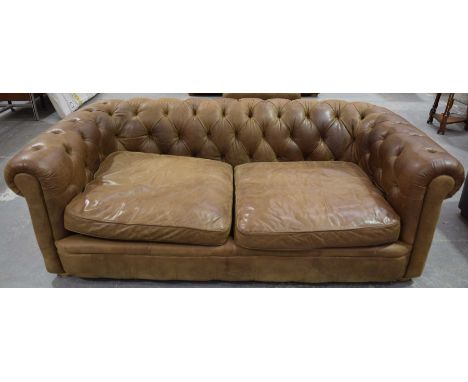A stunning contemporary tan leather Chesterfield leather setteeThe deep set button back and padded arms enclosing a pair of l