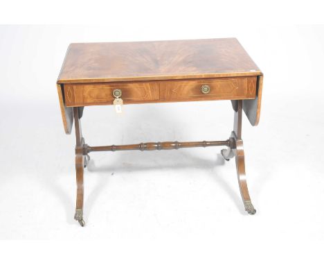A Regency style mahogany sofa tableHaving a rectangular drop leaf top above two frieze drawers, raised upon four downswept su