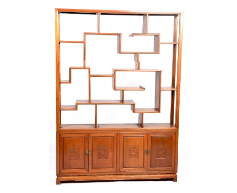 A Chinese Huanghuali style display cabinet The open work cabinet with a series of traditional scroll compartments and shelves