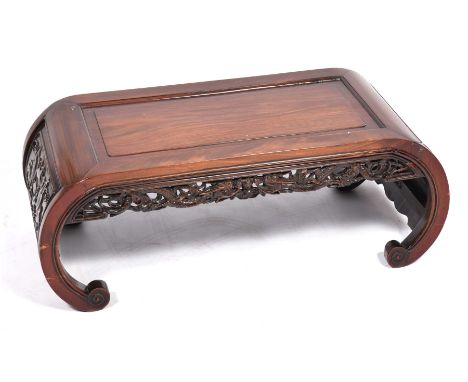 A Chinese Huanghuali style hardwood low kang table, circa 1900 Raised on curved scroll supports, the single plank inset top b