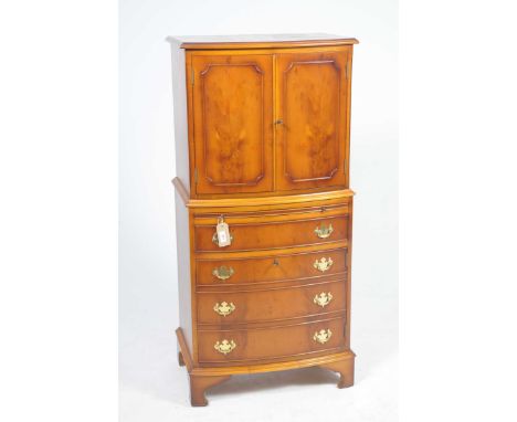 A reproduction yew bow front drinks cabinetIn the Georgian style with a pair of cupboard doors above a single frieze drawer a