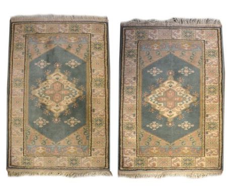 Pair of modern Middle Eastern rugs, each decorated with a central medallion on a jade green ground within multi borders   Con