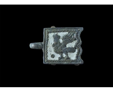 12th-14th century AD. A rectangular plaque with scrolled rear edge, integral loop, white enamel panel with reserved motif of 