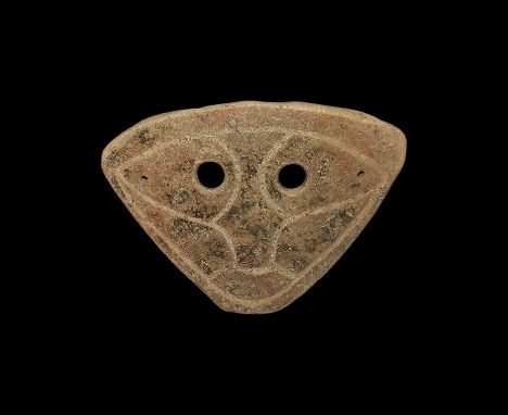 4th-3rd century BC. A trapezoidal slightly domed ceramic mask with two eye-holes and incised stylised facial details; pierced