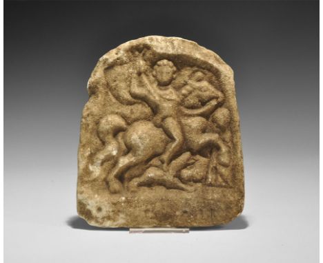 1st-2nd century AD. A D-shaped marble stele with scene in high relief of a horseman on a galloping horse, short cloak over hi