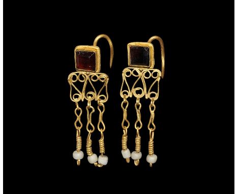 2nd-3rd century AD. A matched pair of gold earrings, each a square plaque with hook to the reverse, panel of scrolled filigre