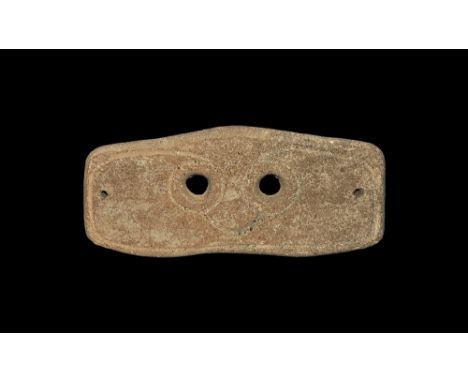 4th-3rd century BC. A rectangular slightly curved ceramic mask with two eye-holes and incised stylised facial details; pierce