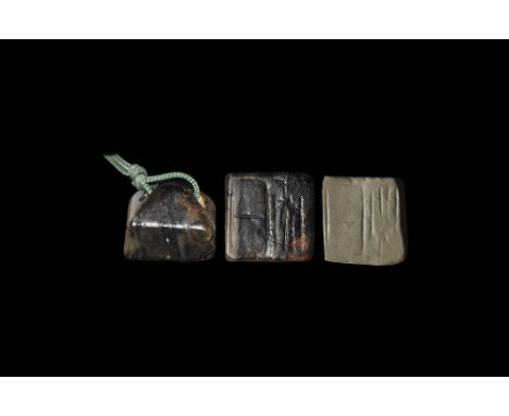 19th century AD. A carved dark onyx seal with pyramidal back pierced for suspension and green silk cord loop; the square face