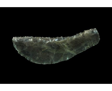 Neolithic, 3rd-2nd millennium BC. A knapped and polished flint knife with a convex and a concave serrated edge. 60 grams, 10.