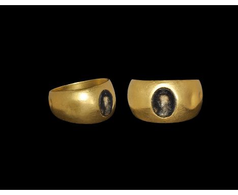 1st-3rd century AD. A broad, flat-section tapering gold hoop with inset sard plaque, intaglio profile bust of Serapis with mo