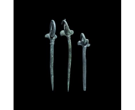 12th-13th century AD. A group of three bronze pins, each a tapering shank and ribbed collar, bird-head finial with ring-and-d