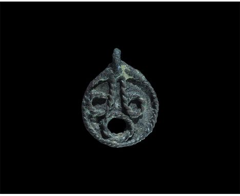 10th-14th century AD. A bifacial discoid silver plaque with integral loop, applied filigree to border and rim to circular hol