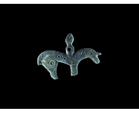 10th-13th century AD. A flat-section bronze pendant of a horseman with conical helmet or hat, ring-and-dot motifs to the hors