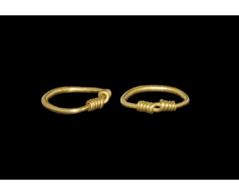 9th-12th century AD. A round-section gold hoop with tapering ends coiled over the shank. 3.64 grams, 22mm overall, 15.9mm int