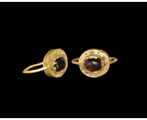 3rd-4th century AD. A gold swivel ring with thin shank running through a hollow bezel which has a flat head with filigree pat