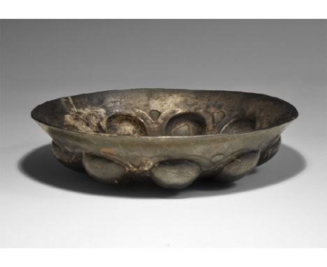4th century BC. A silver carinated bowl with radiating repoussé ovoid panels and central omphalos. 306 grams, 17cm (6 3/4"). 