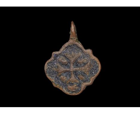 13th-15th century AD. A bronze quatrefoil pendant with pierced lug above, reserved border and arms on a blue enamelled field;