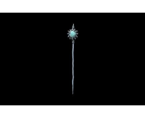 12th-14th century AD. A slender tapering silver pin with wire coiled around the shank above and below the discoid plaque with