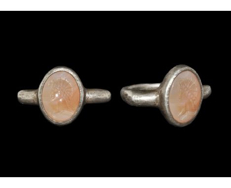 1st-2nd century AD. A round-section silver hoop expanding to keeled shoulders, elliptical cell with inset agate cabochon, int