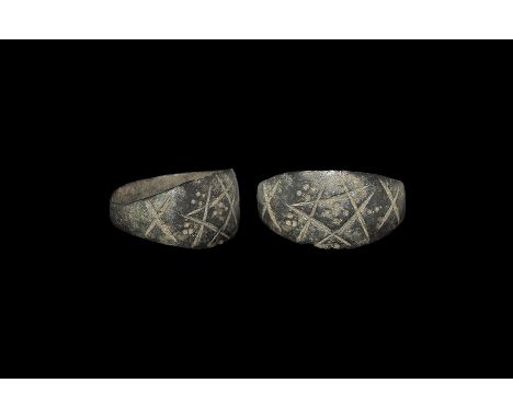 12th-15th century AD. A flat-section bronze hoop with starburst on each shoulder, plaque with incised pentagram and pellets. 