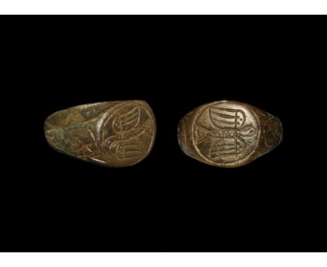 10th-12th century AD. A D-section bronze hoop with expansing shoulders and discoid bezel; to each shoulder a piriform panel w