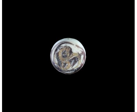 1st-2nd century AD. A discoid glass insert for a finger ring in white and red, with inlaid gold triskele to the upper face. 1