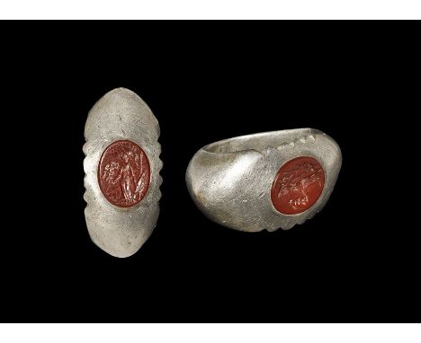 3rd century AD. A substantial D-section silver hoop and expanding shoulders, flat plaque with notched edges and inset carneli