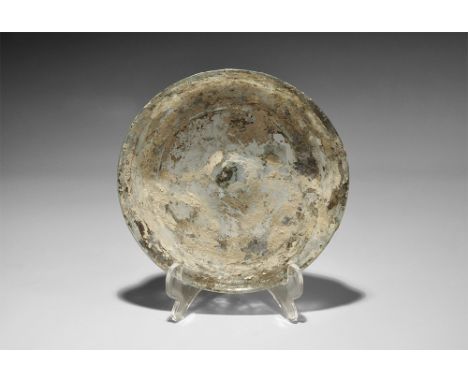 1st century AD. A shallow blue glass dish with central dimple, basal ring, flared sidewall and everted rim. 88 grams, 16cm (6