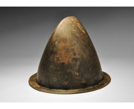 Late 16th century AD. A cabasset with keeled profile, flared rim with rolled edge, small spur to the apex of the keel; row of