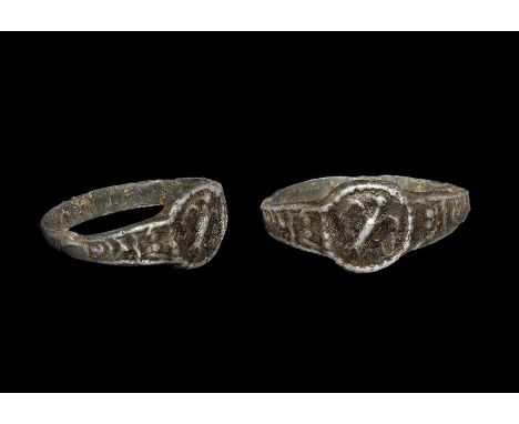 9th-12th century AD. A copper-alloy flat-section hoop with discoid plaque, with raven in flight motif. 1.71 grams, 16mm overa