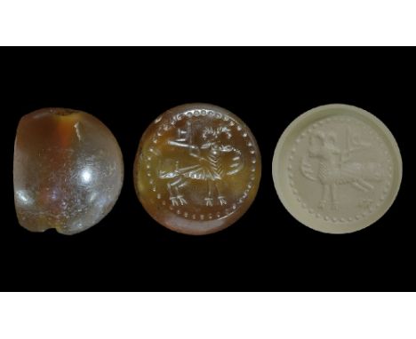 3rd-7th century AD. A carved agate seal matrix with intaglio design of a ram within a beaded border, with symbols around; sup