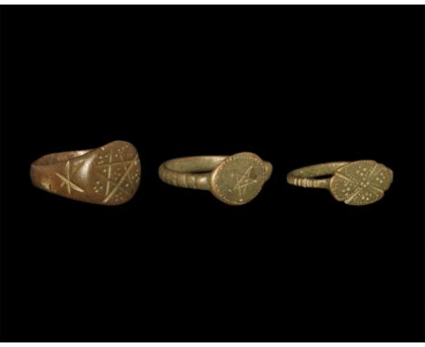 13th-15th century AD. A mixed group of bronze finger rings comprising: one with D-section hoop, discoid bezel with beaded bor