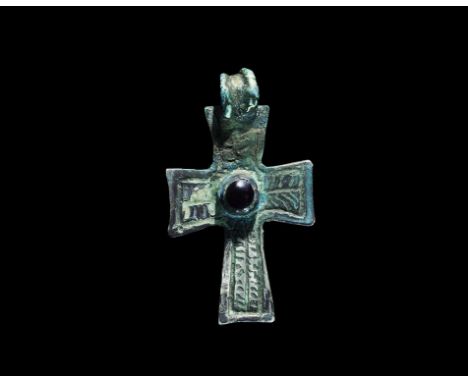11th-12th century AD. A silver flat-section expanding-arm cross pendant with integral ribbed loop, hatched panel to each arm,