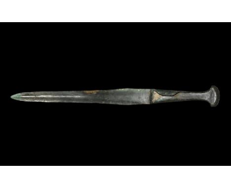 Circa 1000 BC. A large bronze dagger with lozenge-section narrowing blade, transverse guard, grip with flanged edges to accep