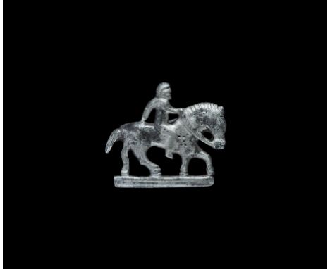 2nd century AD. A silver plate brooch in the form of a horse and rider on a tiered base, modelled in the half-round; the hors