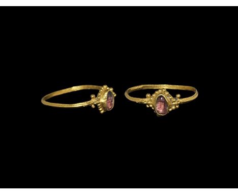 14th century AD. A D-section gold hoop with granules to the shoulders and edges of the plaque, ovoid cell with inset cabochon