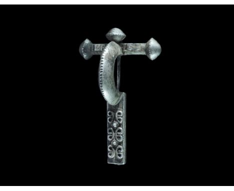 4th century AD. A hollow-formed silver bow brooch with round-section cross bar and biconical bulb finials with notched rim, t