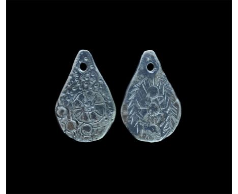 9th-11th century AD. A silver pendant, axe (?) shaped, pierced at the top and decorated with a large sun burst pattern on one