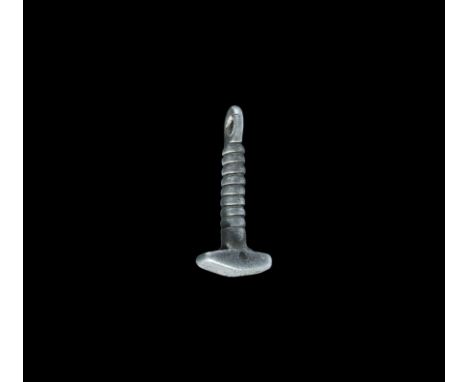 9th-12th century AD. A miniature silver mallet with rectangular head and curved outer face with incised transverse lines, rib