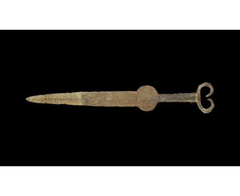 8th-6th century BC. A iron dagger or short stabbing sword with spine down centre of blade, heart shaped chappe; grip recessed